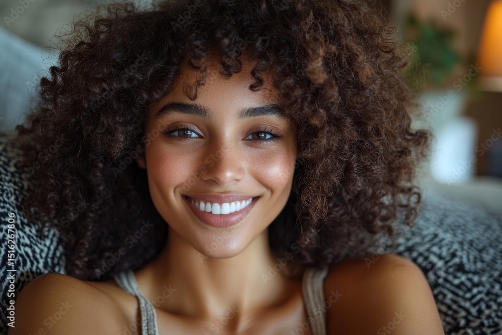 Close up portrait of a smiling woman with curly hair lying on a patterned pillow in a relaxed pose Close up portrait of a smiling woman with curly hair lying on a patterned pillow in a relaxed pose