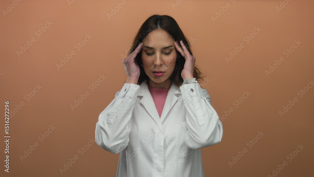 Woman experiencing stress in a white coat against an isolated brown background, highlighting a moment of concentration. Woman experiencing stress in a white coat against an isolated brown background, highlighting a moment of concentration.