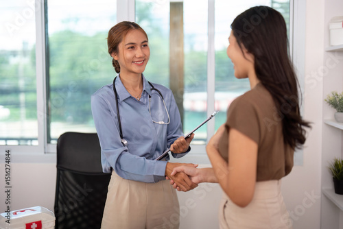 Positive Healthcare Encounter. Nurse and patient sharing a handshake in a consultation.