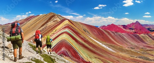 Rainbow mountains with three tourists or hikers