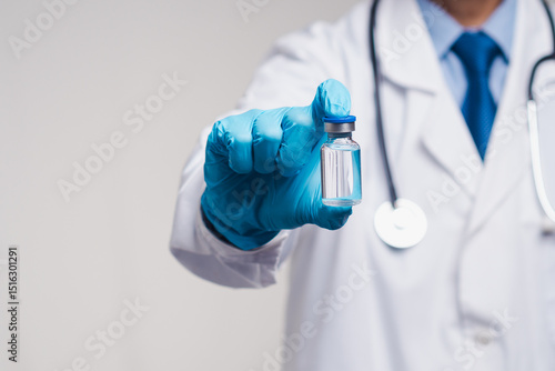 фотографія Doctor in gloves holding clear vaccine vial, concept of immunization, health care, and prevention