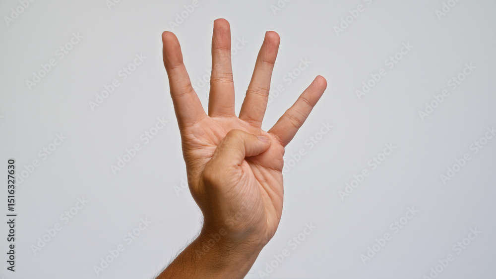 Naklejka premium Man showing four fingers against a plain white background with a close-up view of his hand in an open gesture