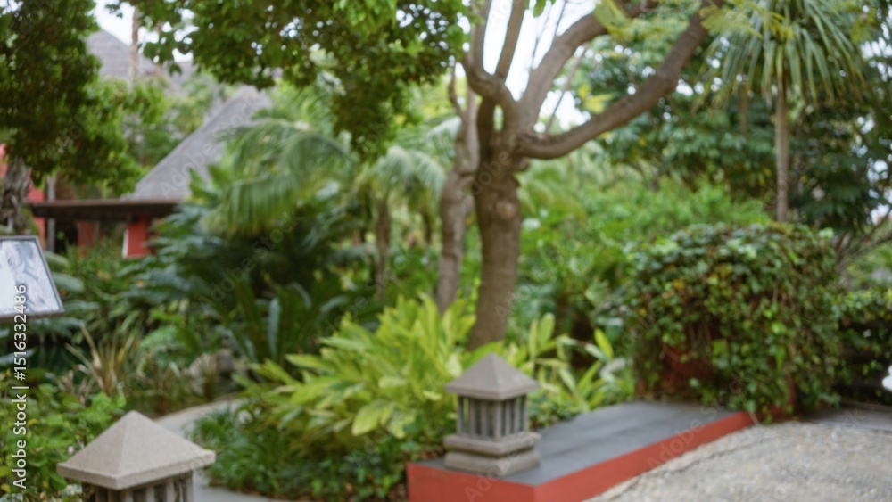 Fototapeta premium Blurred tropical resort with lush greenery and outdoor scenery, featuring defocused trees and plants creating a serene luxury atmosphere with bokeh effect.