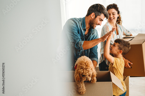 Happy family with cardboard boxes in new house at moving day. Mortgage, family, real estate concept