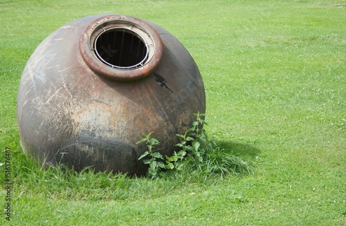 Großes Tongefäß auf einer Wiese als Gartendeko.