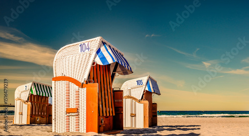 Fototapeta Naklejka Na Ścianę i Meble -  Beachside cabins lined on a sunny day showcasing vibrant colors and clear skies in a coastal location