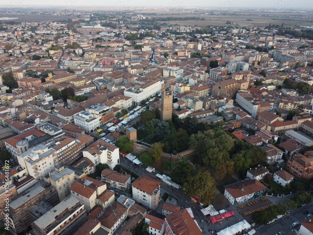 Fototapeta premium Aerial drone view of Rovigo city center, Veneto, showcasing the medieval Donà Tower, ancient castle ruins, and a mix of historic and modern buildings.