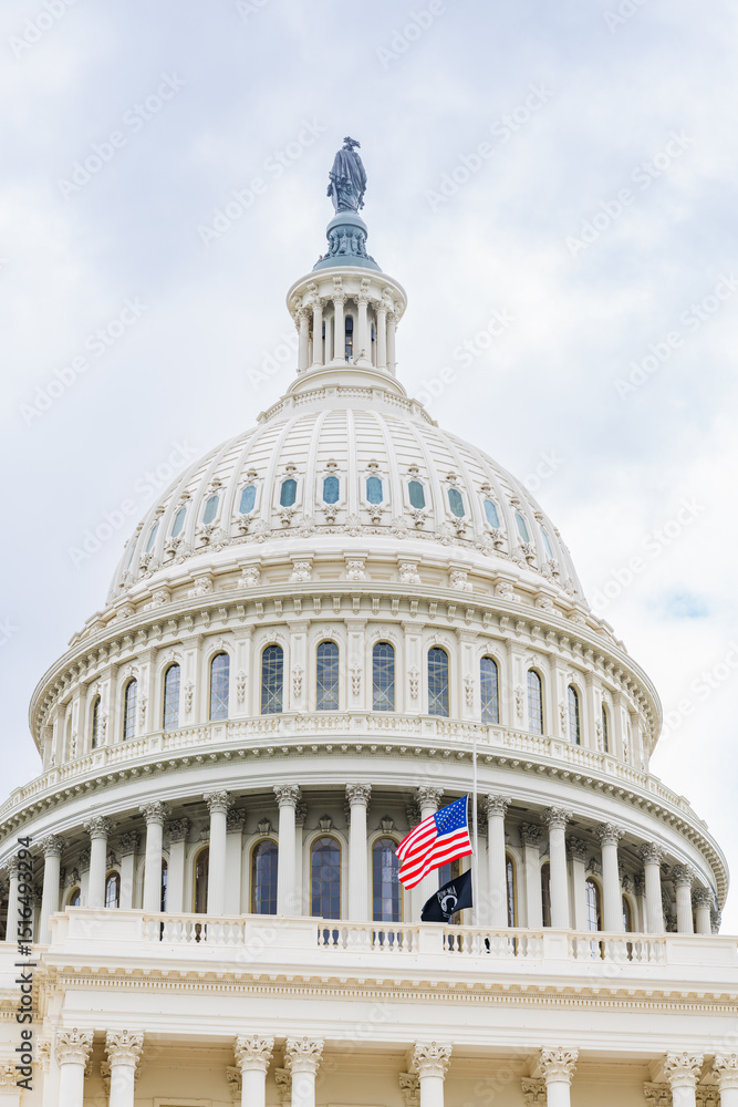 Fototapeta premium Close-up of the U.S. Capitol dome with American and POW flags flying at half-staff.