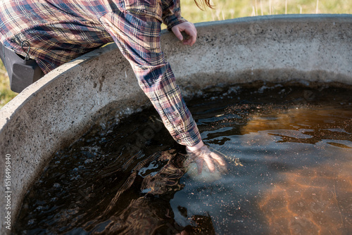 Photography female farmer fixing a water trough on a farm