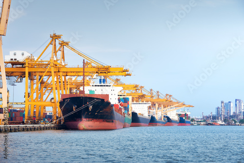 Large crane and cargo ship transport cargo container and docked at port in Bangkok of Thailand. Business industry of shipping, logistics, international global trade, freight transport, import export.