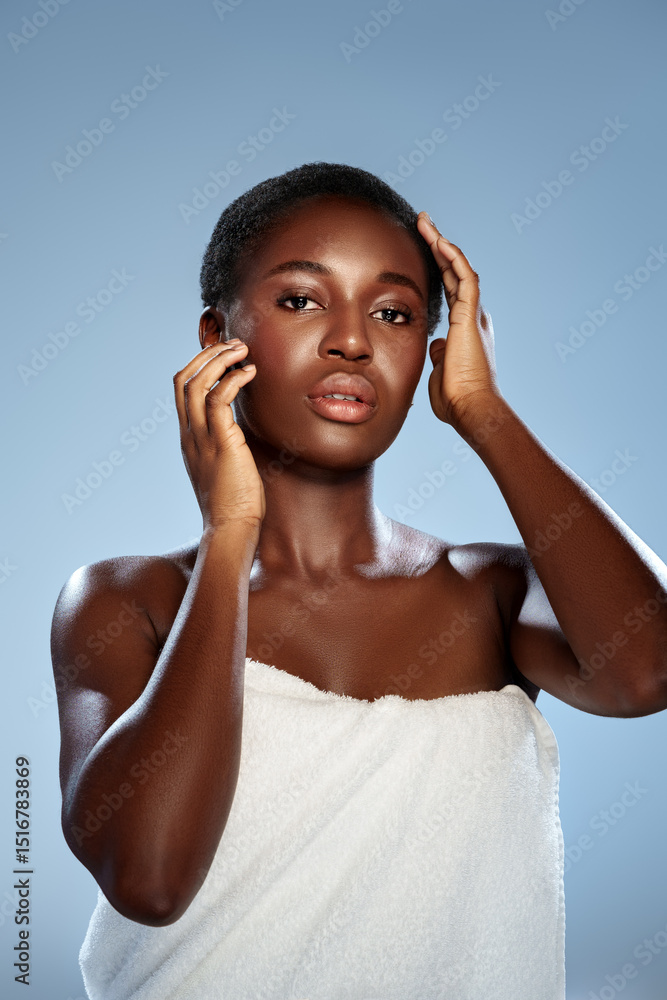 Fototapeta premium Woman poses elegantly with a towel in a studio setting during a beauty shoot focusing on skincare and natural beauty