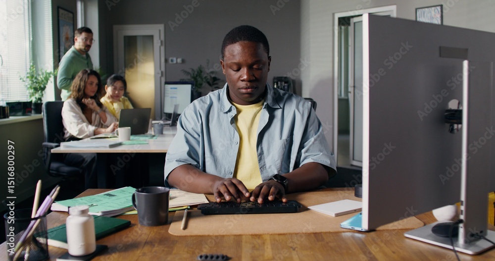 A serious man typing on a computer in the office. His colleagues work nearby. Accelerated video A serious man typing on a computer in the office. His colleagues work nearby. Accelerated video