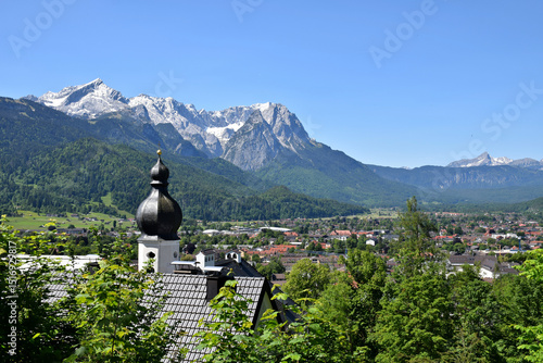 A stunning view of the Wetterstein Mountains as seen from Garmisch-Partenkirchen, Germany. Towering alpine peaks, including Zugspitze —dominate the landscape.
