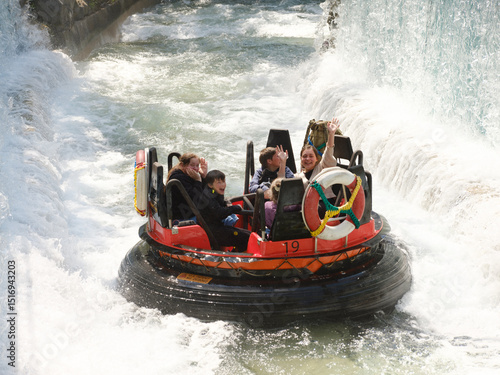 Wildwasserbahn im Freizeitpark mit lachenden Menschen