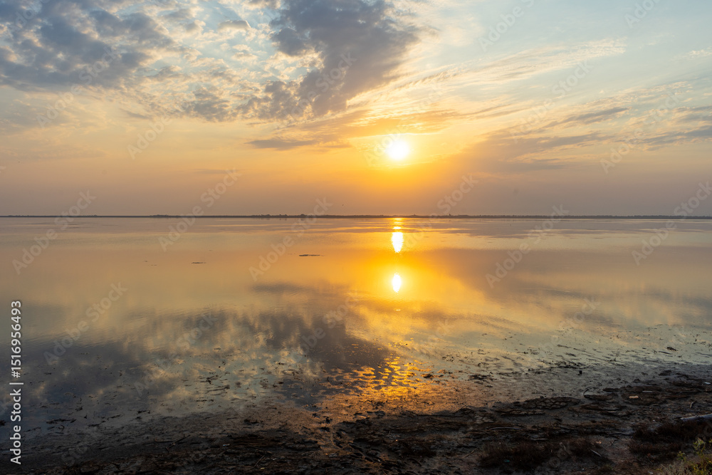 Obraz premium Golden sunset over the Tuzlivsky estuaries in Lebedivka, Ukraine, creating a peaceful and picturesque natural landscape.