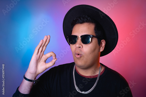 Man signaling ok and nodding towards the camera on a multicolored background