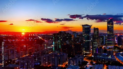 Aerial cityscape view with illuminated buildings and a colorful sky at dusk in an urban landscape