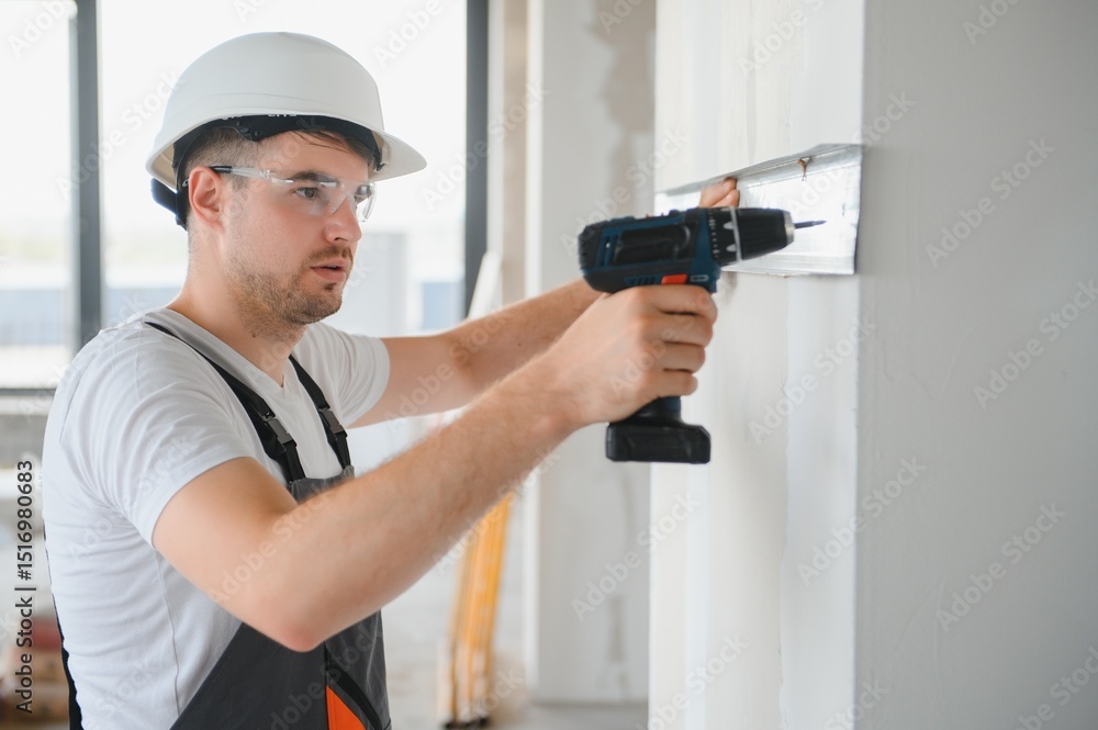 Handsome young male builder in hard hat, while working at construction site. Handsome young male builder in hard hat, while working at construction site.