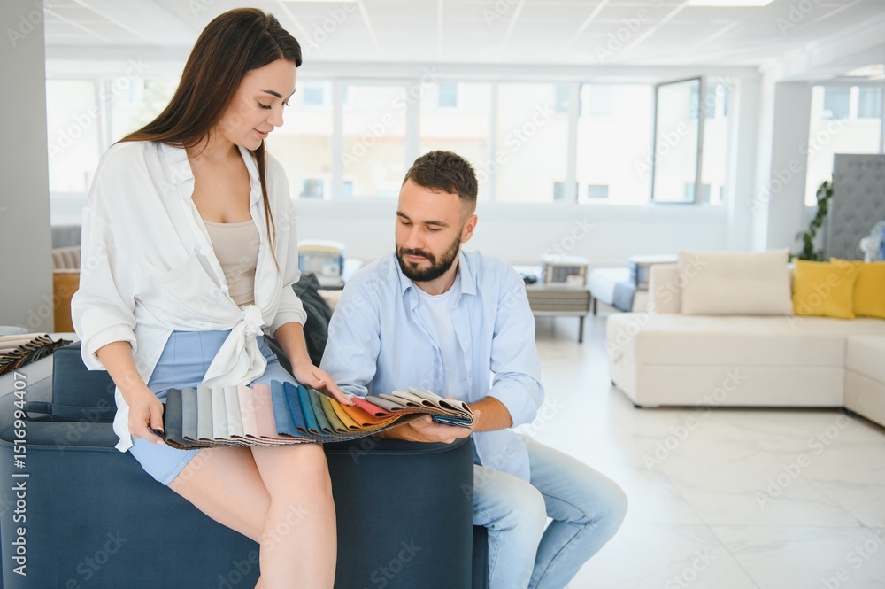 Fototapeta premium Married couple chooses the best new sofa in a furniture store