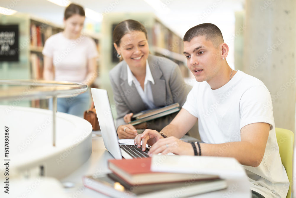 Female student talking to male student near laptop, they are preparing for exams and diploma