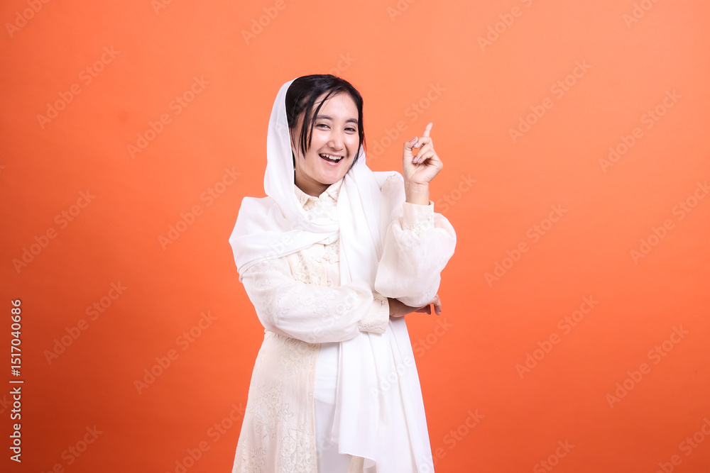 Enthusiastic muslim woman pointing upwards, conveying inspiratio Enthusiastic muslim woman pointing upwards, conveying inspiratio