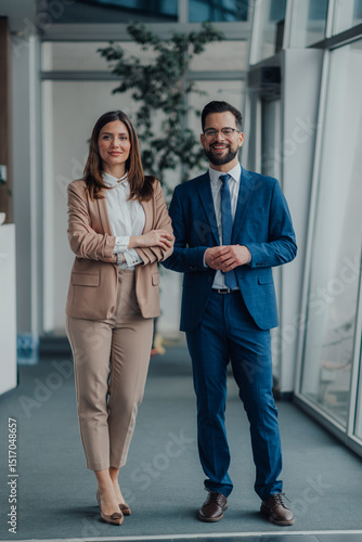 Obraz na płótnie Portrait of two business people smiling in modern office hallway