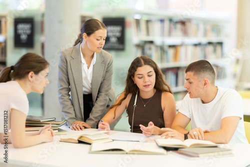 Friendly group of students prepare for classes and exams by studying together in the university library