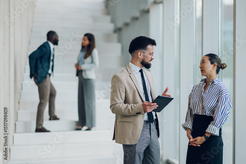Photography Business people discussing using digital tablet in office hallway