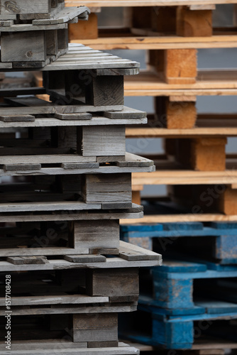 A stack of wooden pallets with one blue and one brown. The blue pallet is on top of the brown pallet