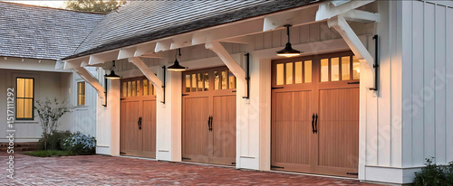 A charming farmhousestyle garage exterior with white board and batten siding two white carriagestyle garage doors with black hardware Above each door is a d