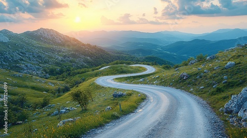 Scenic winding mountain road at sunset with rolling hills in the background