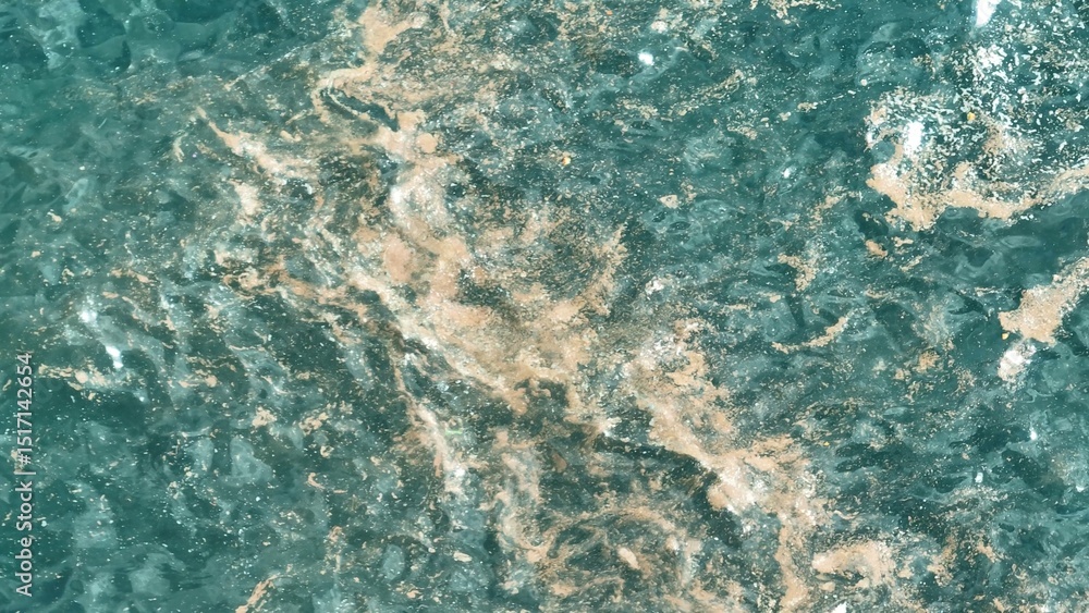 Fototapeta premium Drone captures the disturbing sight of microplastics floating on the water's surface, a stark reminder of the long-lasting impact of pollution on marine ecosystems. 