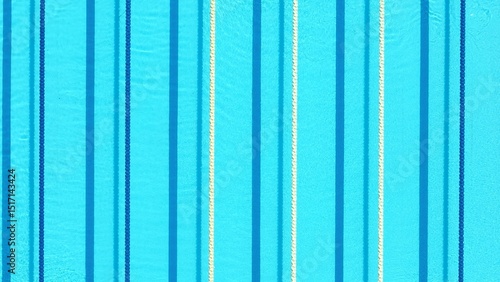 Fotografía From above, the swimming pool appears tranquil and inviting, with the blue water reflecting the lane markers, creating a peaceful oasis for relaxation and swimming