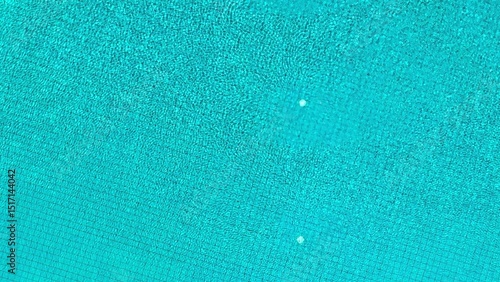 Captured from above, the pool's smooth surface and neatly arranged tiles create an inviting and peaceful atmosphere, with gentle ripples enhancing the serene view.
