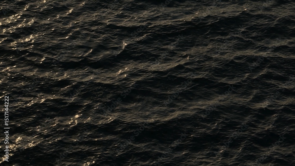 Obraz premium The ocean’s waves are illuminated by the warm glow of the sun, with golden sparkles reflecting on the water’s surface, creating an enchanting and peaceful atmosphere. 