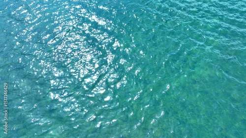 A mesmerizing aerial view of the tropical sea, where the waves glisten with the reflection of sunlight, capturing the powerful yet serene motion of nature in this beautiful ocean landscape.
