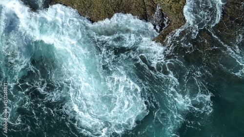 A turbulent seascape where wind-driven waves collide with rocky shores, swirling foam and demonstrating the raw power of nature’s weather systems on the ocean’s surface. Phuket, Thailand.