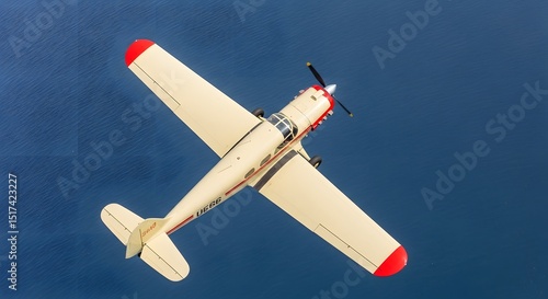 Vintage Red and White Biplane Flying Against a Clear Blue Sky