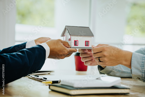 Billede på lærred Two people exchanging house keys and signing documents, symbolizing home buying, mortgage, investment, and financial planning in real estate