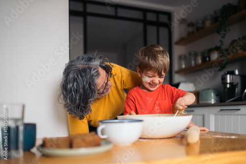 Grandmother and grandson baking together in the kitchen