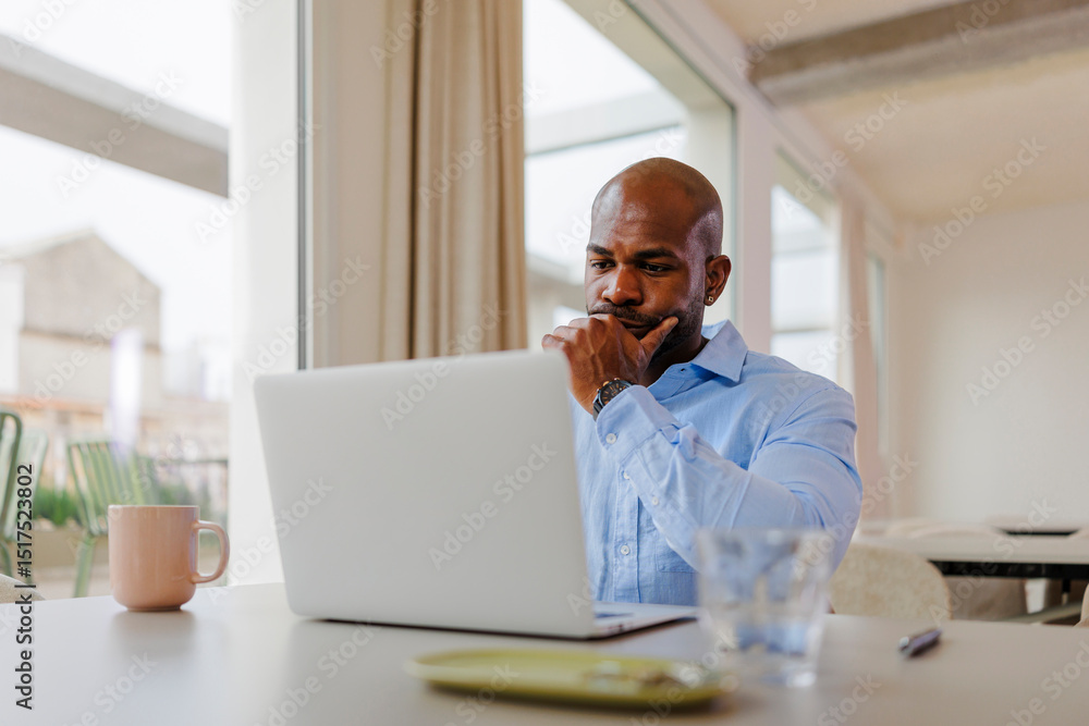 Focused businessman working on laptop in modern office Focused businessman working on laptop in modern office