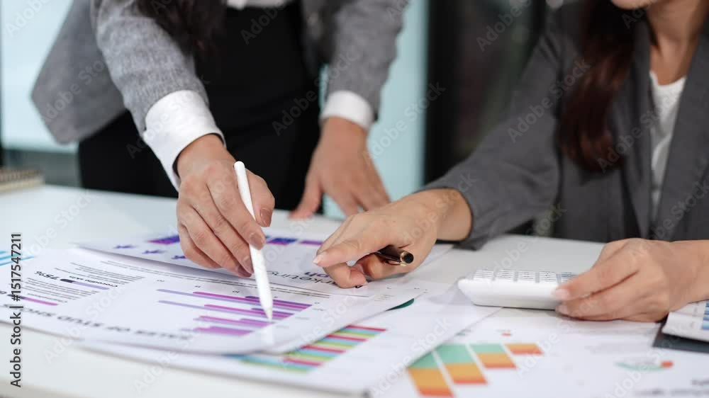 Two Asian businesswomen discussing graphs in a meeting Two Asian businesswomen discussing graphs in a meeting