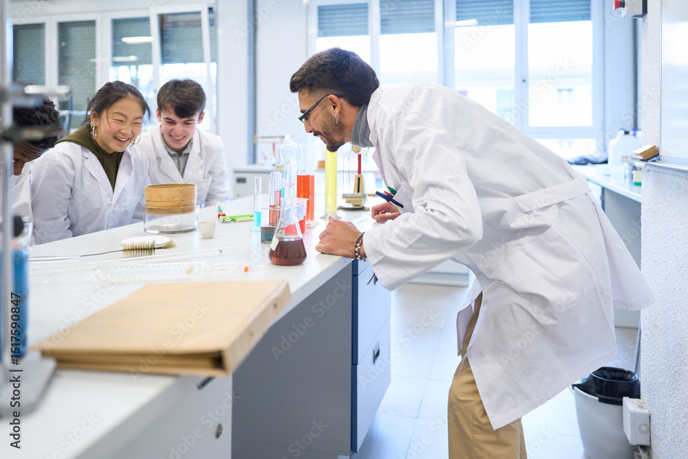 Chemistry teacher showing experiment results to students in laboratory Chemistry teacher showing experiment results to students in laboratory
