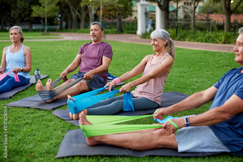 Mature people in circle using stretch band at park