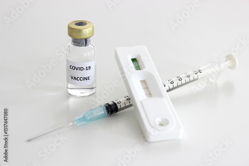 Vial of Covid-19 vaccine, 1 ml plastic syringe with needle and Positive test result of Covid-19 antigen test kit isolated on the white background