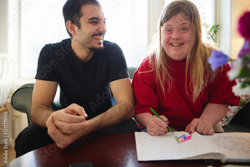Wallpaper Mural Happy woman with down syndrome coloring on book while sitting near male nurse in nursing home Torontodigital.ca
