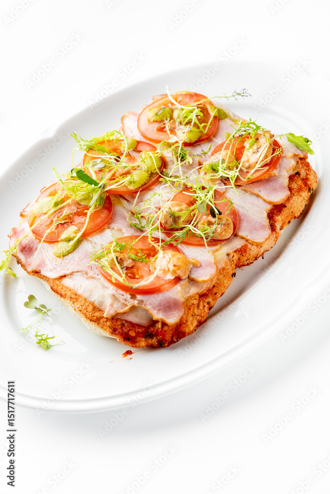 Open-faced sandwich with ham, tomato slices, microgreens, and a creamy sauce on a white plate. The vibrant colors and fresh ingredients make it visually appealing and appetizing. Open-faced sandwich with ham, tomato slices, microgreens, and a creamy sauce on a white plate. The vibrant colors and fresh ingredients make it visually appealing and appetizing.