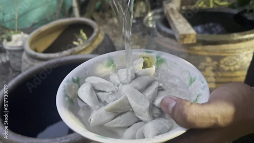 Asian cook is cooking in thai kitchen in local traditional country style, preparing fresh fish balls to cook thai food green curry popular worldwide