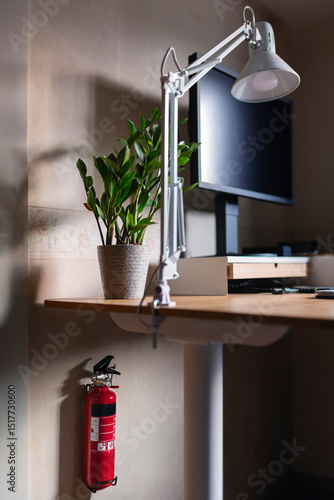Wallpaper Mural Fire extinguisher mounted on wall under desk with electric lamp and desktop PC Torontodigital.ca