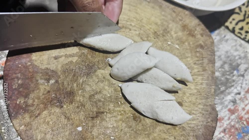 Asian cook is cooking in thai kitchen in local traditional country style, preparing fresh fish balls to cook thai food green curry popular worldwide